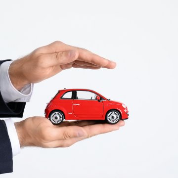 root car insurance features car insurance man in black suit holding red toy car in palm 